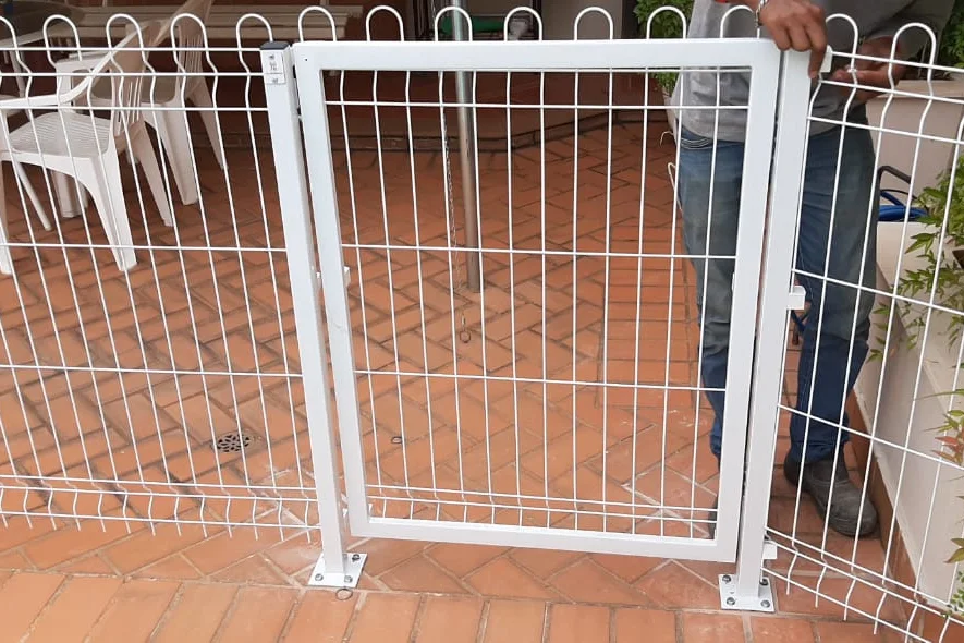 Portão de painel soldado branco, com moldura tubular, instalado em cercamento de área externa